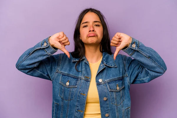 Mor arka planda izole edilmiş genç İspanyol kadın hoşlanmadığı bir hareket gösteriyor. Anlaşmazlık konsepti.