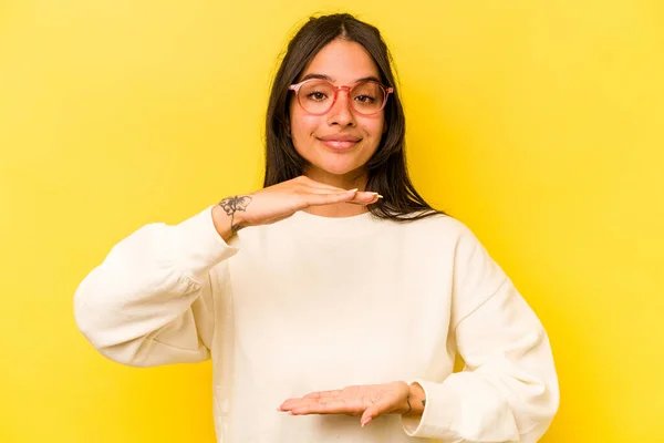Young Hispanic Woman Isolated Yellow Background Holding Something Both Hands —  Fotos de Stock