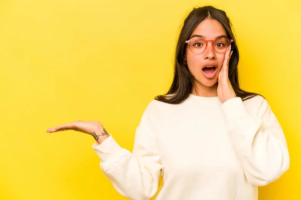 Young Hispanic Woman Isolated Yellow Background Impressed Holding Copy Space — Foto de Stock