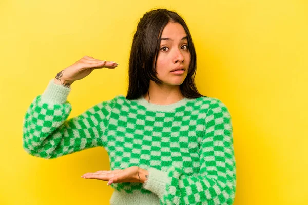 Young Hispanic Woman Isolated Yellow Background Holding Something Both Hands —  Fotos de Stock