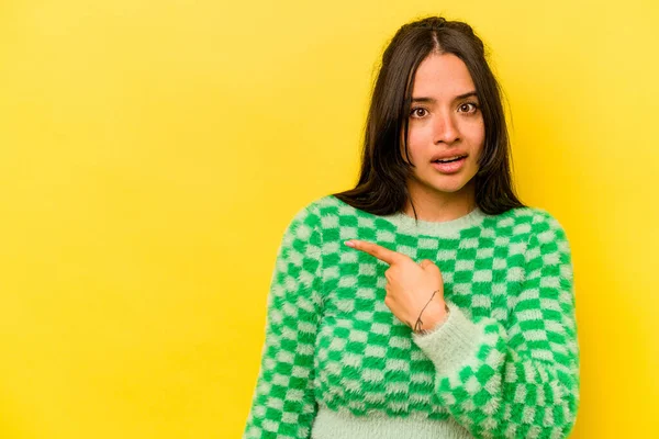 Sarı arka planda izole edilmiş genç İspanyol kadın...