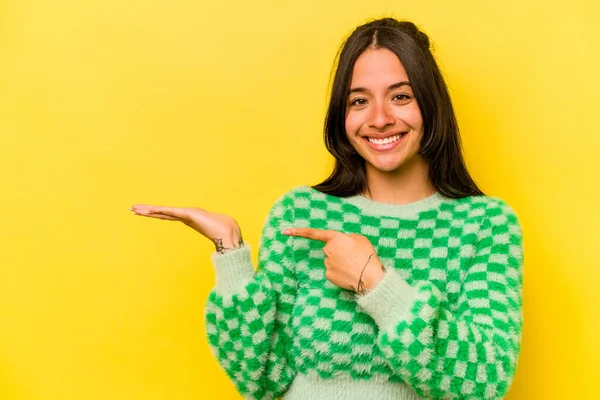 Sarı arka planda izole edilmiş genç İspanyol bir kadın..