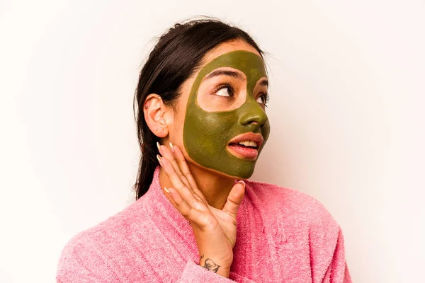 Beyaz arka planda izole edilmiş yüz maskesi takan genç İspanyol kadın.