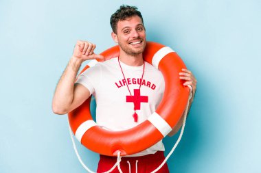 Young caucasian lifeguard man isolated on blue background feels proud and self confident, example to follow.
