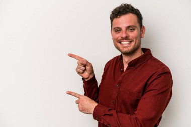 Beyaz arka planda izole edilmiş genç beyaz bir adam işaret parmağıyla işaret ettiği için heyecanlı..