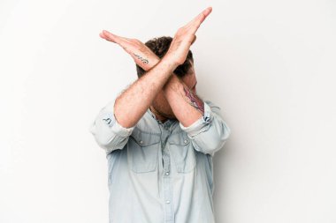 Beyaz arka planda izole genç beyaz adam iki kolu çapraz tutuyor, inkar kavramı.