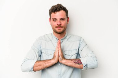 Beyaz arka planda izole edilmiş genç beyaz adam dua ediyor, bağlılık gösteriyor, dindar biri ilahi ilham arıyor..