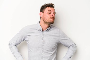 Beyaz arka planda izole edilmiş genç beyaz adam hedeflere ve amaçlara ulaşmayı hayal ediyor.