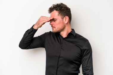 Beyaz arka planda izole olmuş genç beyaz bir adam başı ağrıyor, yüzüne dokunuyor..