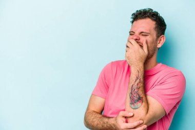 Kafkasyalı genç adam mavi arka planda yalnızdı gülerek, kaygısızca, doğal duygularla.