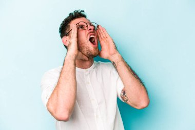 Mavi arka planda izole edilmiş beyaz bir adam heyecanlı bir şekilde bağırıyor..