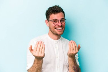 Kafkasyalı genç adam mavi arka planda izole edilmiş seni işaret ediyor sanki davet ediliyormuş gibi..