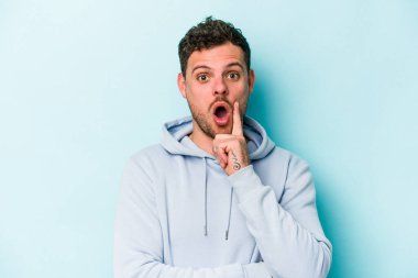 Kafkasyalı genç adam mavi arka planda izole edildi. Harika bir fikri var, yaratıcılık kavramı..