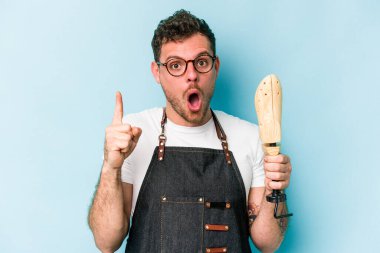 Kafkasyalı genç kunduracı, mavi arka planda izole edilmiş. Harika bir fikri var, yaratıcılık kavramı..