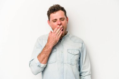 Beyaz arka planda izole edilmiş genç beyaz adam esniyor. Ağzı eliyle kapatan yorgun bir hareket sergiliyor..