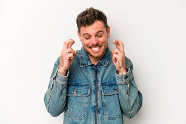 Beyaz arka planda izole genç beyaz adam şans dilemek için şans diliyor.