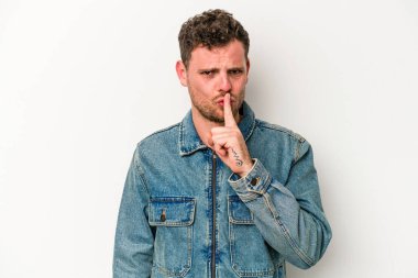 Beyaz arka planda izole edilmiş genç beyaz bir adam ya sır saklıyor ya da sessizlik istiyor..