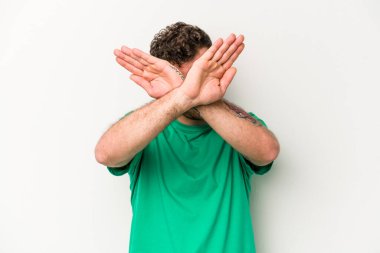 Beyaz arka planda izole genç beyaz adam iki kolu çapraz tutuyor, inkar kavramı.