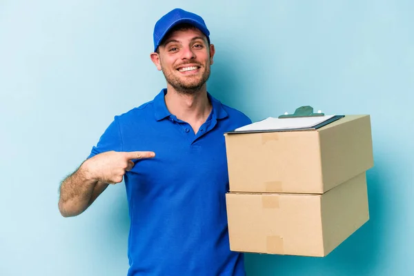 Young Caucasian Delivery Man Isolated Blue Background Person Pointing Hand — стоковое фото
