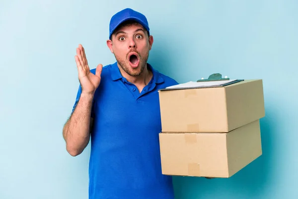 Young Caucasian Delivery Man Isolated Blue Background Surprised Shocked — Stockfoto