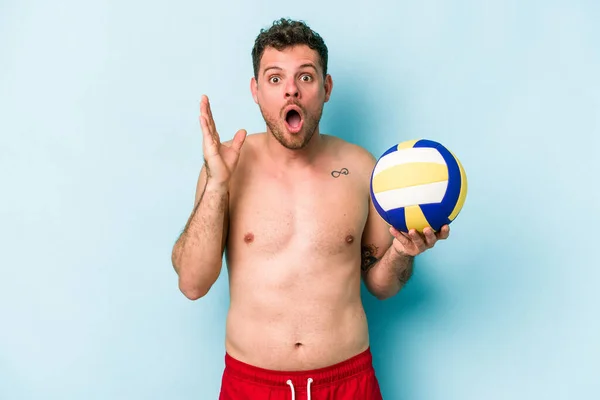 Young Caucasian Man Playing Volley Isolated Blue Background Surprised Shocked — Stok fotoğraf