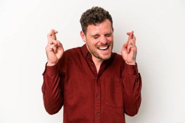 Beyaz arka planda izole genç beyaz adam şans dilemek için şans diliyor.