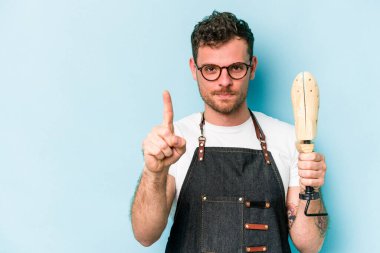 Kafkasyalı genç kunduracı, mavi arka planda bir numarayı parmağıyla gösteriyor..