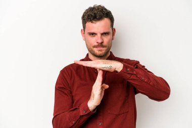 Beyaz arka planda izole edilmiş genç beyaz bir adam bir mola hareketi gösteriyor..