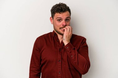 Beyaz arka planda izole edilmiş, tırnak yiyen, gergin ve endişeli genç bir beyaz adam..