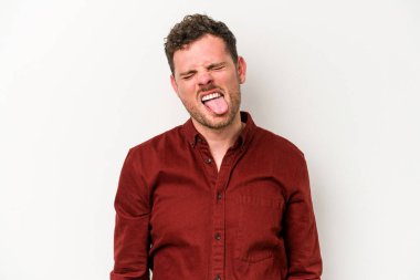 Beyaz arka planda izole edilmiş genç beyaz bir adam. Komik ve dost canlısı bir dil uzatıyor..