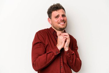 Beyaz arka planda izole edilmiş genç beyaz adam korkmuş ve korkmuş..