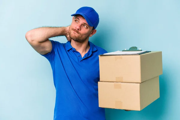 Young Caucasian Delivery Man Isolated Blue Background Touching Back Head — Φωτογραφία Αρχείου