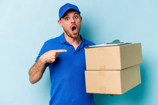 Young Caucasian Delivery Man Isolated Blue Background Pointing Side — Stockfoto