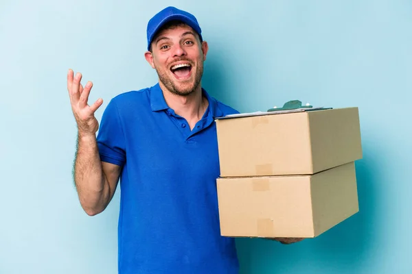 Young Caucasian Delivery Man Isolated Blue Background Receiving Pleasant Surprise — Φωτογραφία Αρχείου