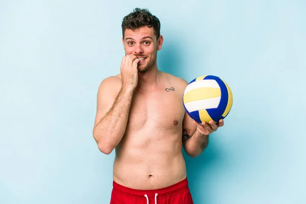Young Caucasian Man Playing Volley Isolated Blue Background Biting Fingernails — Stok fotoğraf