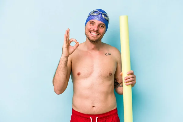 Young Caucasian Swimmer Man Holding Foam Stick Isolated Blue Background — Foto de Stock