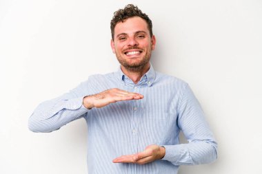 Beyaz arka planda izole edilmiş beyaz bir adam iki eliyle bir şey tutuyor..