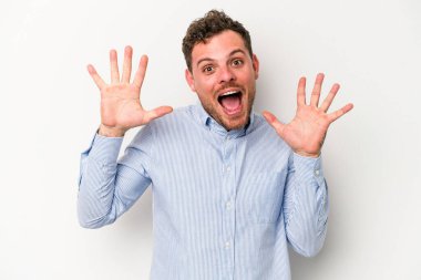 Beyaz arka planda izole genç beyaz adam hoş bir sürpriz alıyor, heyecanlı ve el kaldırıyor..