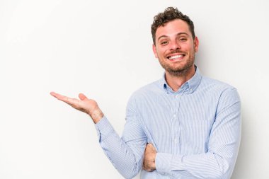 Beyaz arka planda izole edilmiş genç beyaz bir adam bir palmiye üzerinde fotokopi alanı gösteriyor ve belinde başka bir el tutuyor..