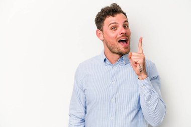 Beyaz arka planda izole edilmiş beyaz tenli genç bir adam bir numarayı parmağıyla gösteriyor..