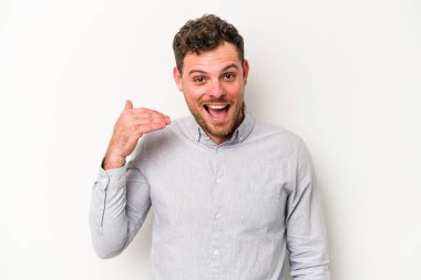 Beyaz arka planda izole olmuş genç beyaz bir adam bir şeye gülüyor, ağızlarını ellerle kapatıyor..