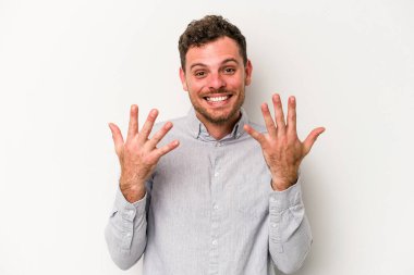 Beyaz arka planda izole edilmiş beyaz tenli genç adam on numarayı elleriyle gösteriyor..