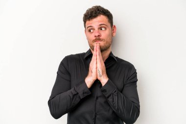 Beyaz arka planda izole edilmiş genç beyaz adam dua ediyor, bağlılık gösteriyor, dindar biri ilahi ilham arıyor..