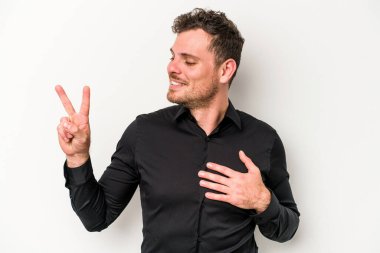 Beyaz arka planda izole edilmiş genç beyaz adam yemin ediyor, elini göğsüne koyuyor..