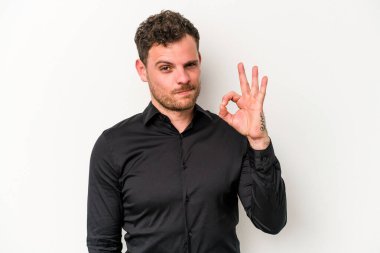 Beyaz arka planda izole edilmiş genç beyaz bir adam bir göz kırptı ve elleriyle iyi bir jest yaptı..