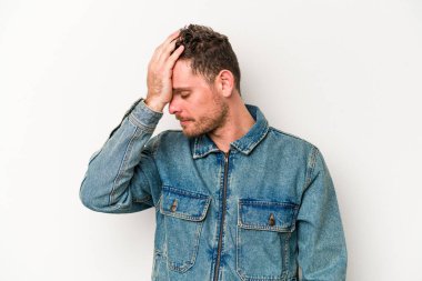 Beyaz arka planda izole edilmiş genç beyaz bir adam bir şeyi unutuyor. Alnına avuç içi ve gözlerini kapayarak vuruyor..