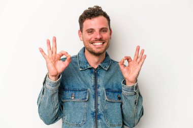 Beyaz arka planda izole edilmiş genç beyaz bir adam neşeli ve kendinden emin..