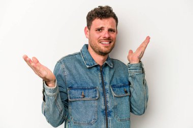 Beyaz arka planda izole edilmiş genç beyaz bir adam. Kafası karışmış ve omuz silkiyor. Kopya alanını tutmak için..