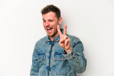 Beyaz arka planda izole edilmiş genç beyaz adam iki numarayı parmaklarıyla gösteriyor..
