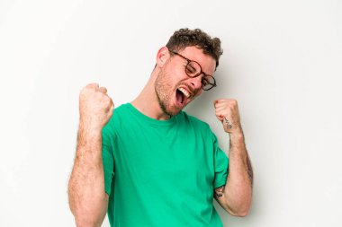 Beyaz arka planda izole edilmiş genç beyaz adam tasasız ve heyecanlı bir şekilde tezahürat yapıyor. Zafer konsepti.